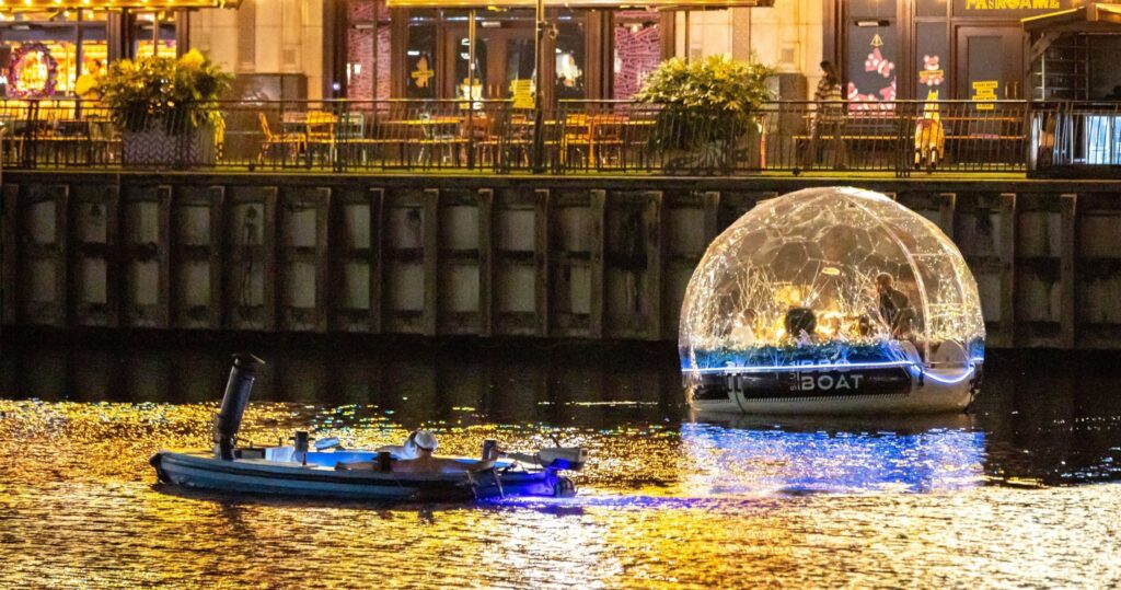 夜晚的 Canary Wharf,冰屋船行駛於水道間,璀璨燈光與水面倒影相映成趣。