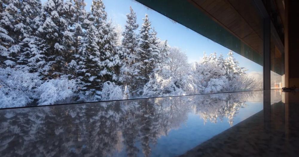 「界・津輕」溫泉池，窗外飄雪與溫暖蘋果溫泉交融的夢幻景色。

