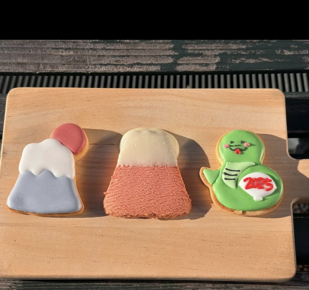 三種以富士山與可愛卡通設計為主題的餅乾,擺放在木質背景上,展現繽紛可愛的手信魅力。