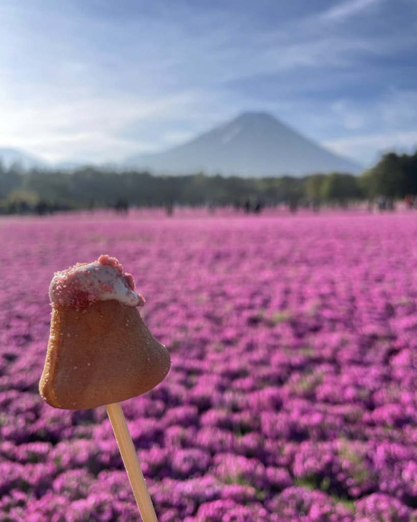以富士山為造型的餅乾,前景是紫色花田,遠處是富士山美景,充滿日本自然與文化的象徵。