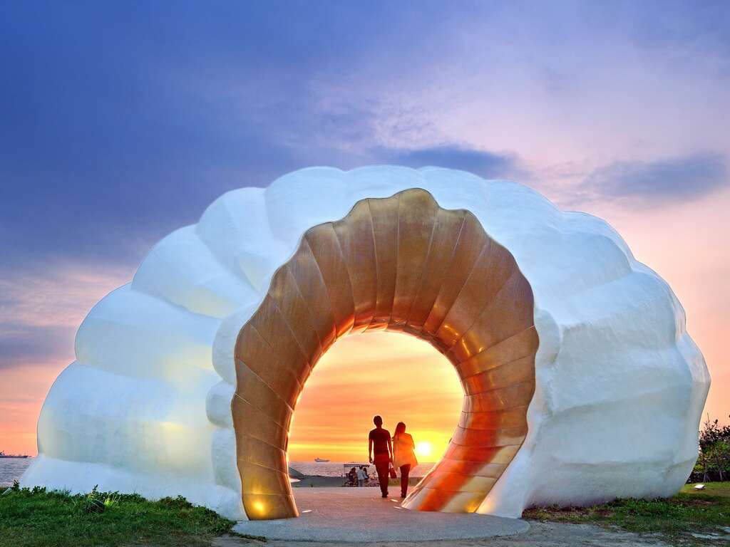 金色海珍珠洞口在夕陽映照下閃耀奪目,陽光穿透洞口與澄黃海面交織出變化萬千的黃金色澤,呈現如夢如幻的絕美景象。